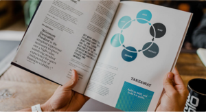 Person reading a magazine with business diagrams.